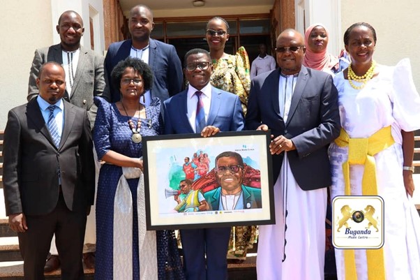 The Katikkiro (centre) receives his portrait from Susan Nsibirwa, CEO of the National Media Group (2nd from left), as a gift Image