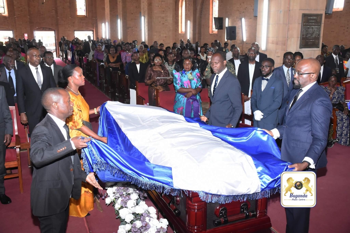 Ministers, led by Owek. Daudi Mpanga, drape the Buganda Kingdom flag over the casket containing the body of the late Owek. Amb. Matovu Ministers, led by Owek. Daudi Mpanga, drape the Buganda Kingdom flag over the casket containing the body of the late Owek. Amb. Matovu