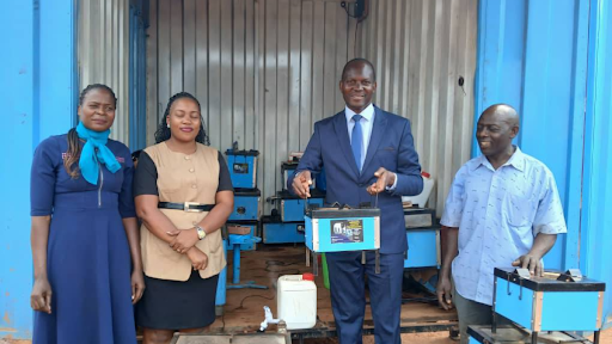 Hon. Noah Kiyimba holding one of the stoves made at the facility