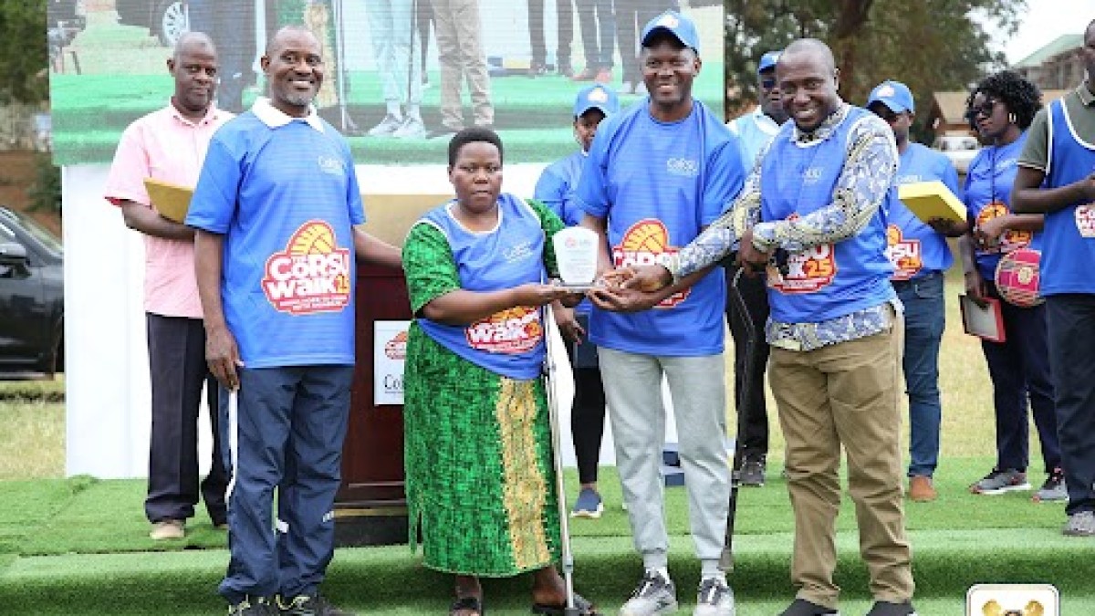 Hon. Noah Kiyimba handing a gift to the winner.
