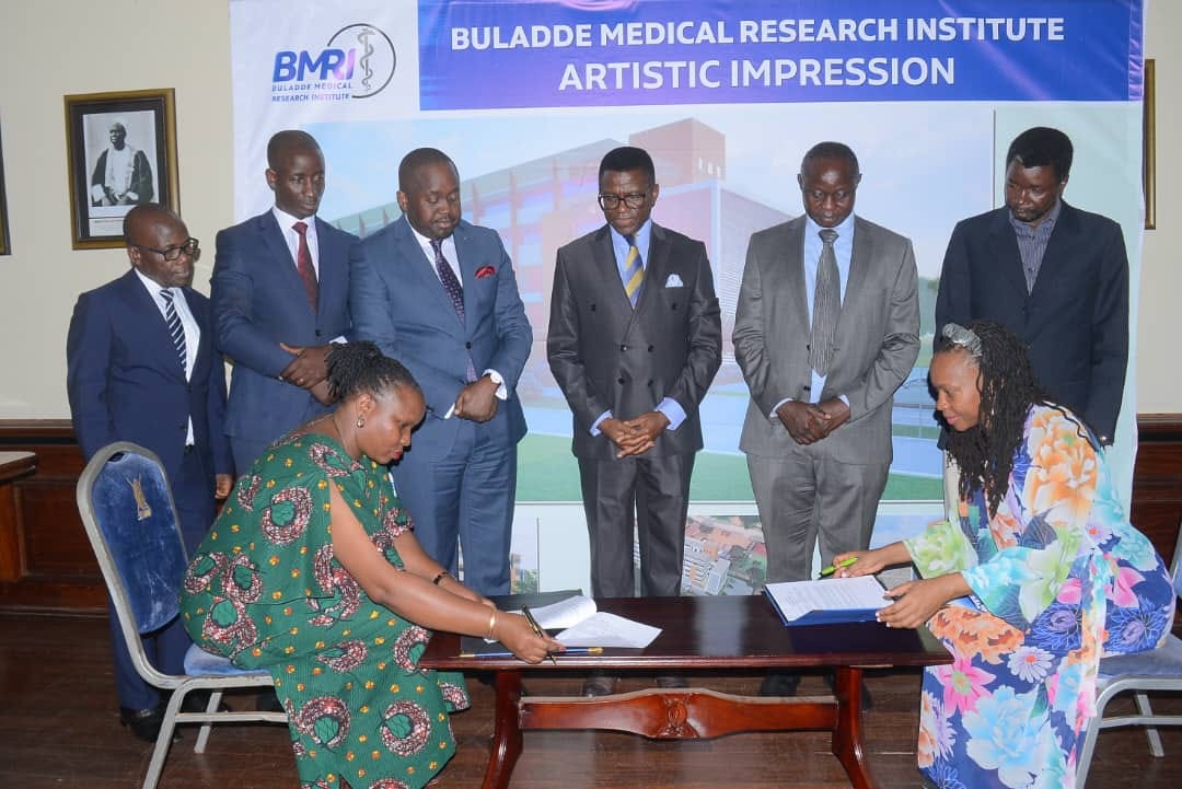 Katikkiro and other officials witnessing the signing of the agreement Image