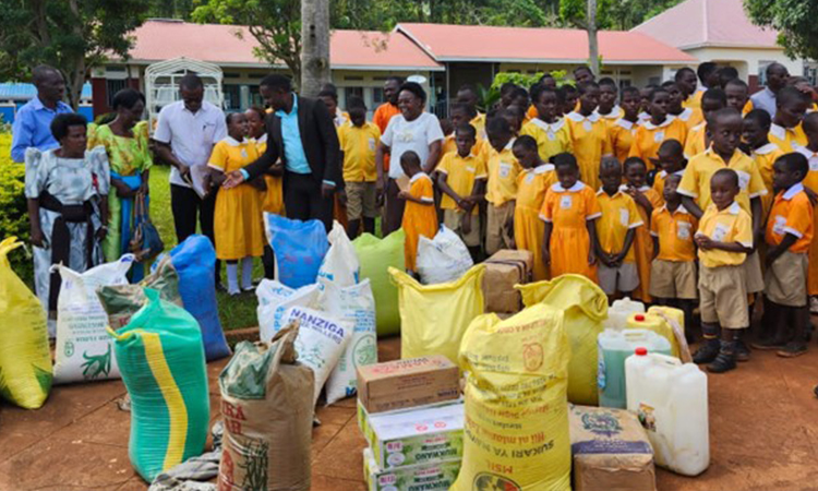 Students and teachers receive aid from King Ronald Muwenda Mutebi II. Image