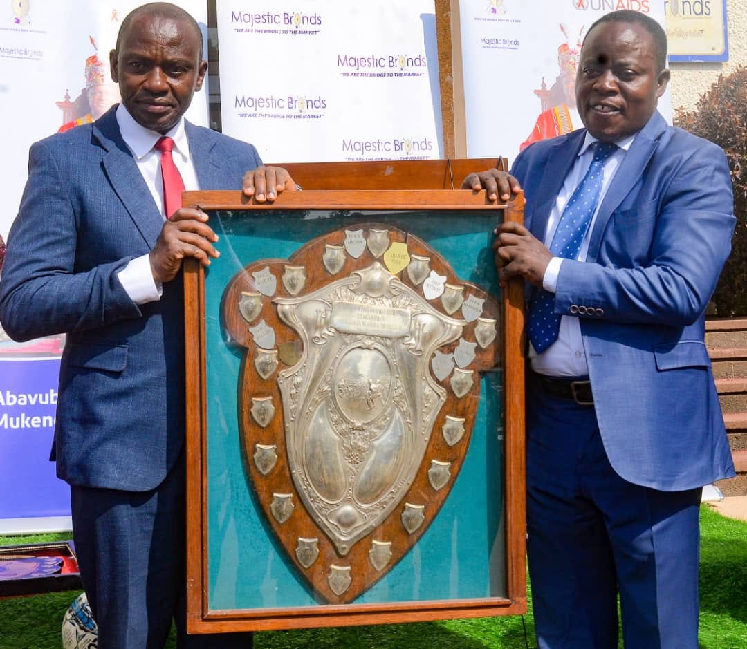Min. Henry Ssekabembe Kiberu on left presenting the Shield given to Men. Image