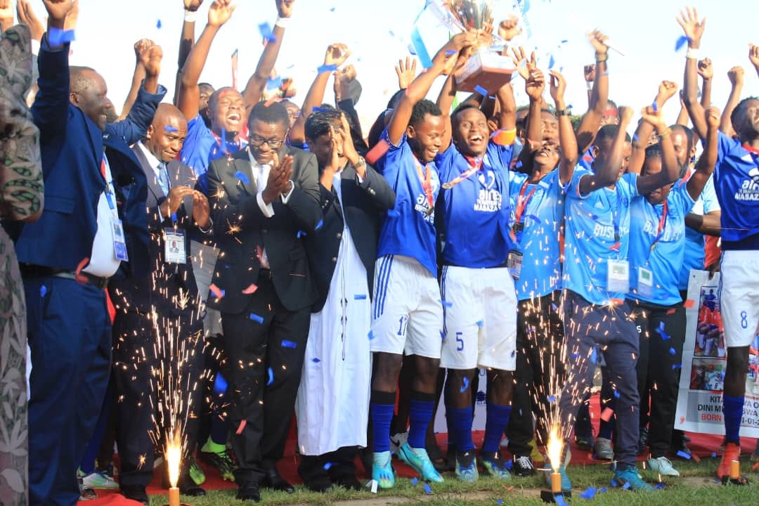 Players and officials from Busiro celebrate after winning the trophy. Image