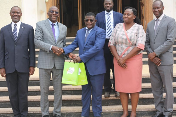 Honorable Prof. Twaha Kigongo Kaawaase in the middle with the CEO of Baylor Uganda Image
