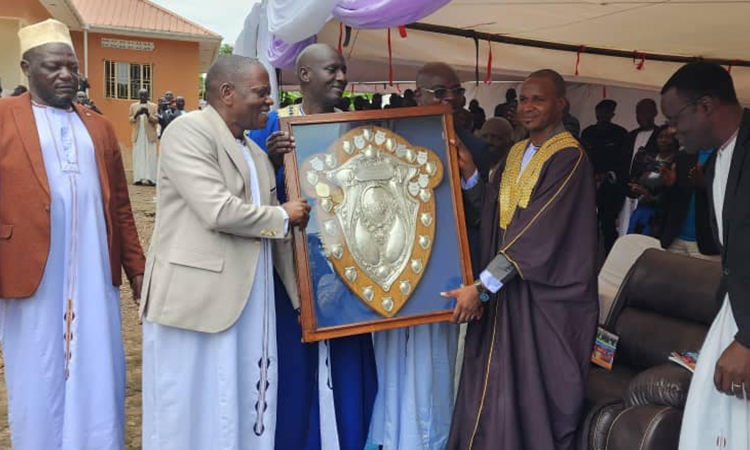 The Hon. Wamala Anthony handed the football shield to the clan head (left). Image
