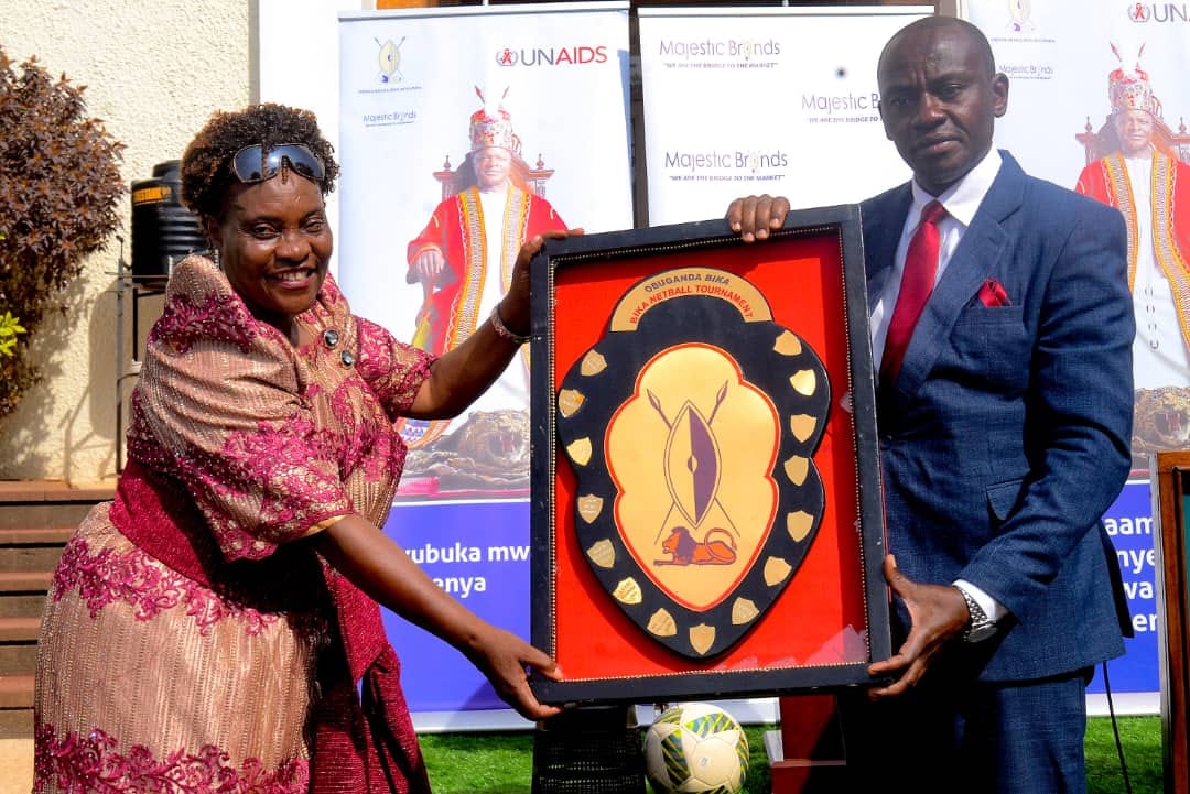 Min. Henry Ssekabembe Kiberu on right presenting the Shield given to women. Image