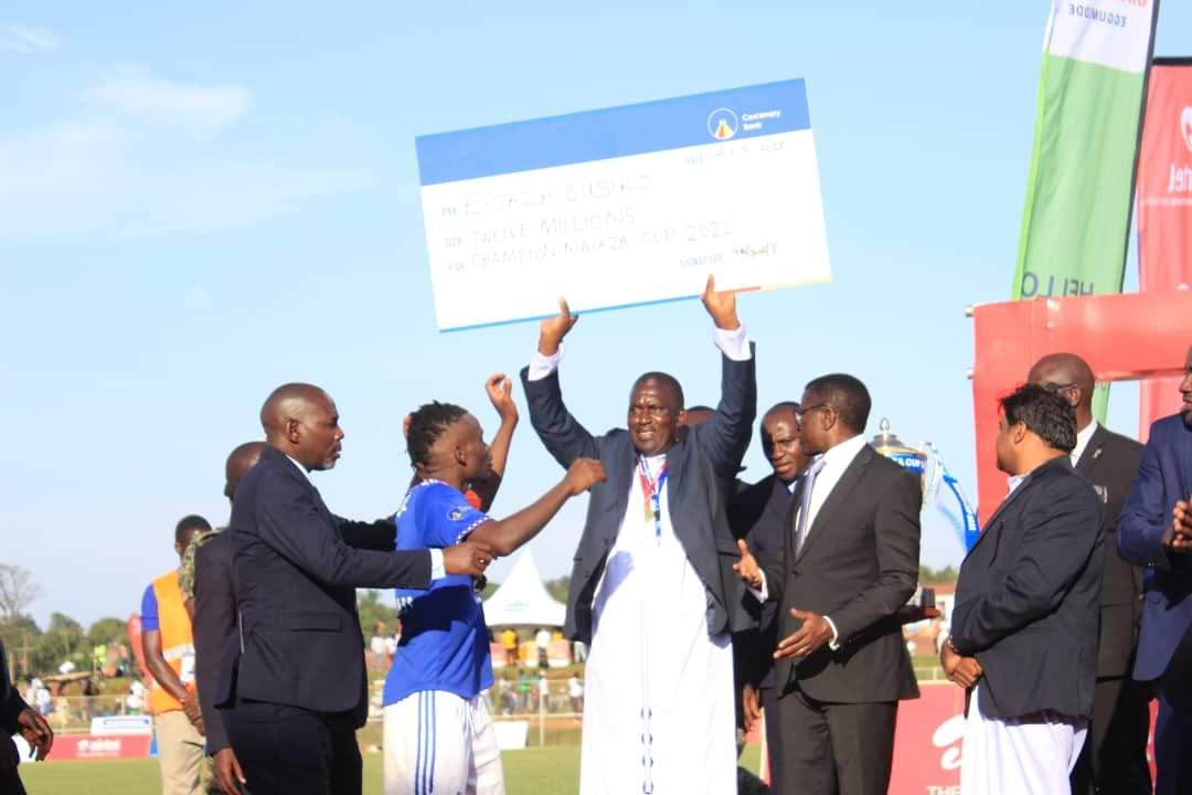 Mr. Ssebwana holding the cheque handed over by the Katikkiro. Image