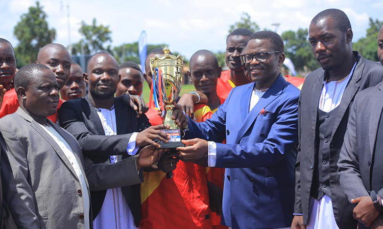 Katikkiro handing over the trophy to the winners. Image